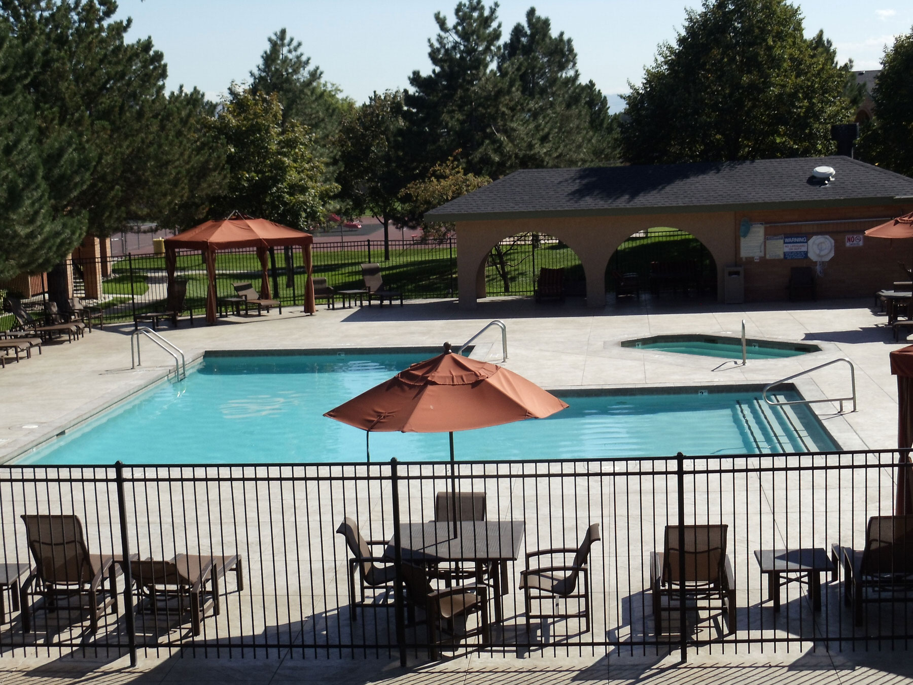 Large L-shaped communal swimming pool with seating around the sides - Precision Pools