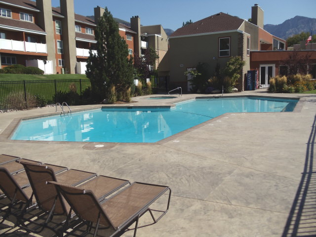 Swimming pool with sun beds surrounded by buildings