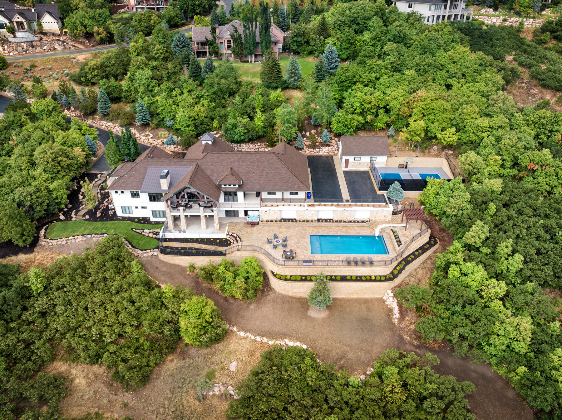 Large house with swimming pool and slide on hillside - Precision Pools